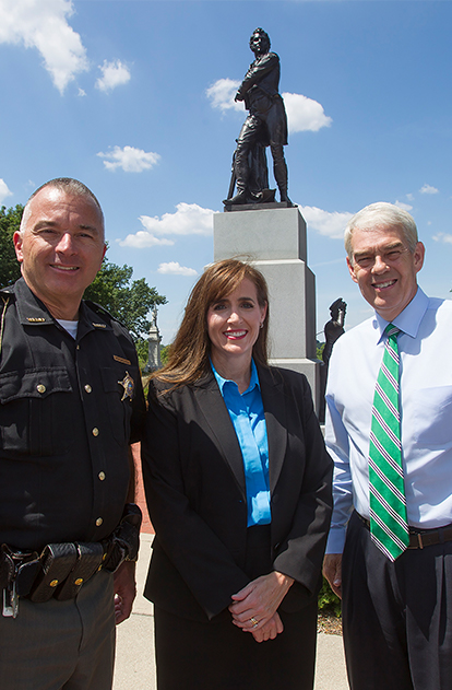 Theresa Gavarone with Sheriff Randy in front of statue